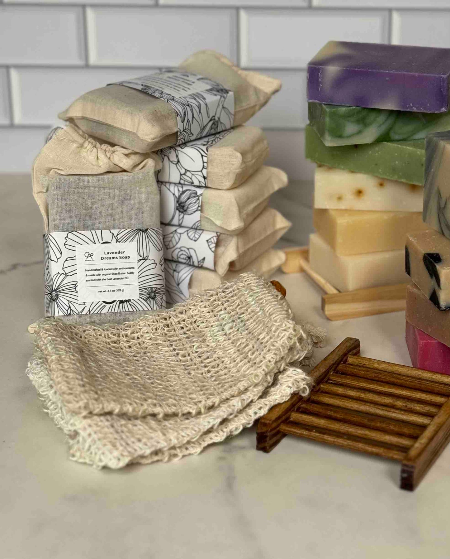 Stacks of various soaps and a washcloth on a neutral background