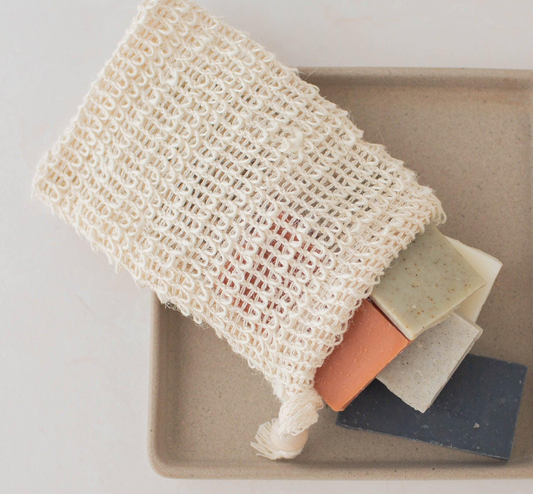 Mesh soap bag with three bars of soap on a beige tray